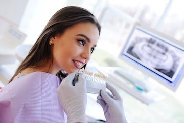 A dental patient comparing tooth shades