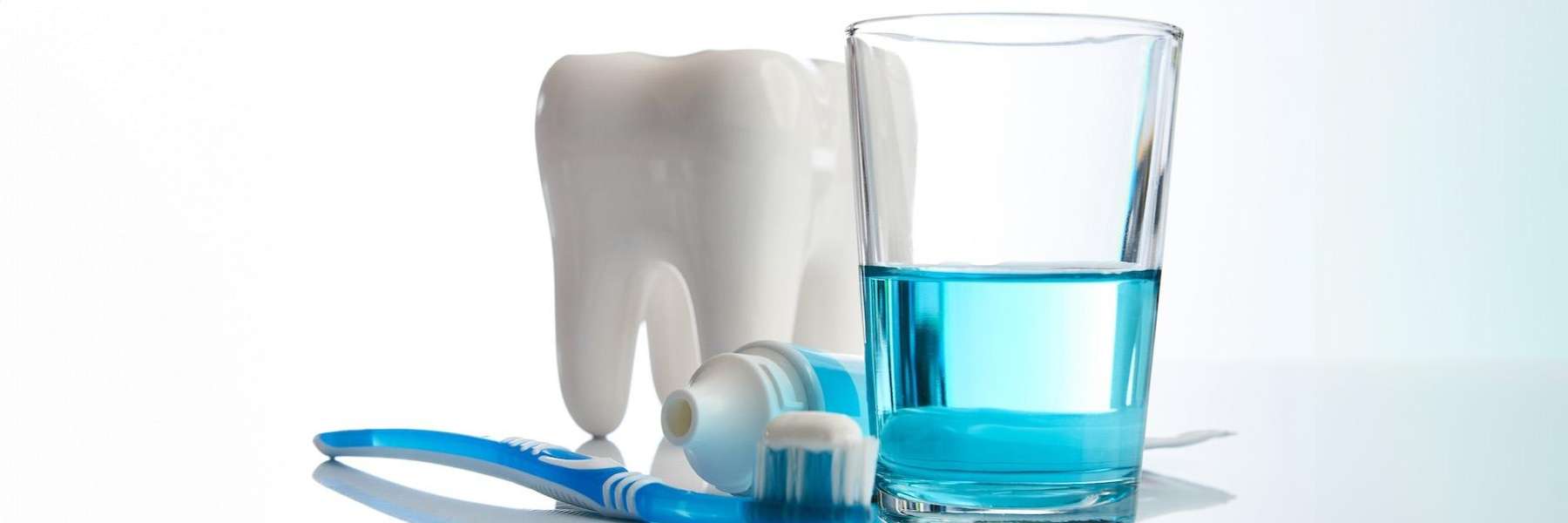 Toothbrush and toothpaste next to a glass with mouthwash in it, south austin tx
