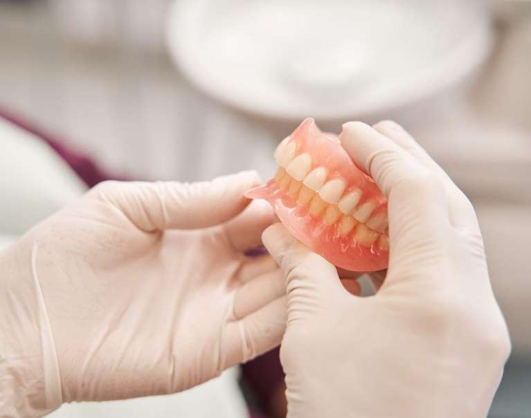 A dentist holding dentures, south austin tx