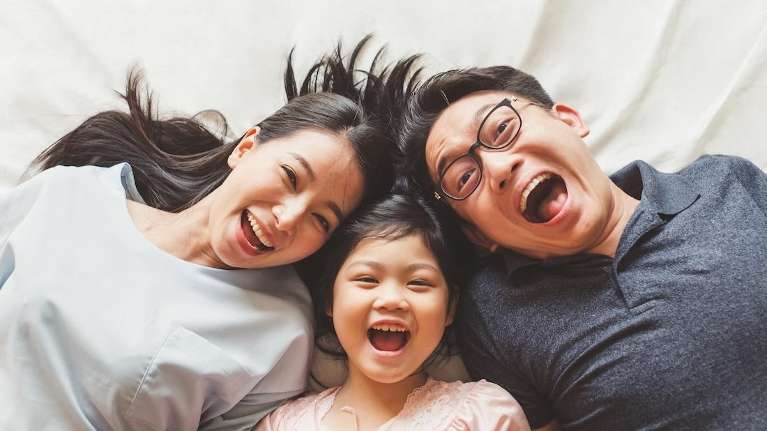 Asian mom, dad, and daughter smiling together, south austin tx