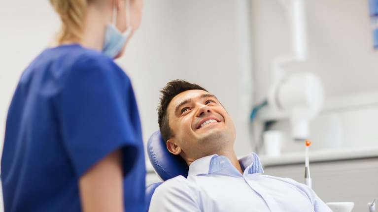 Middle aged man smiling in dentist chair, south austin tx