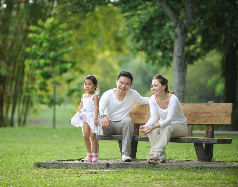 Family smiling together outside in a park, south austin tx