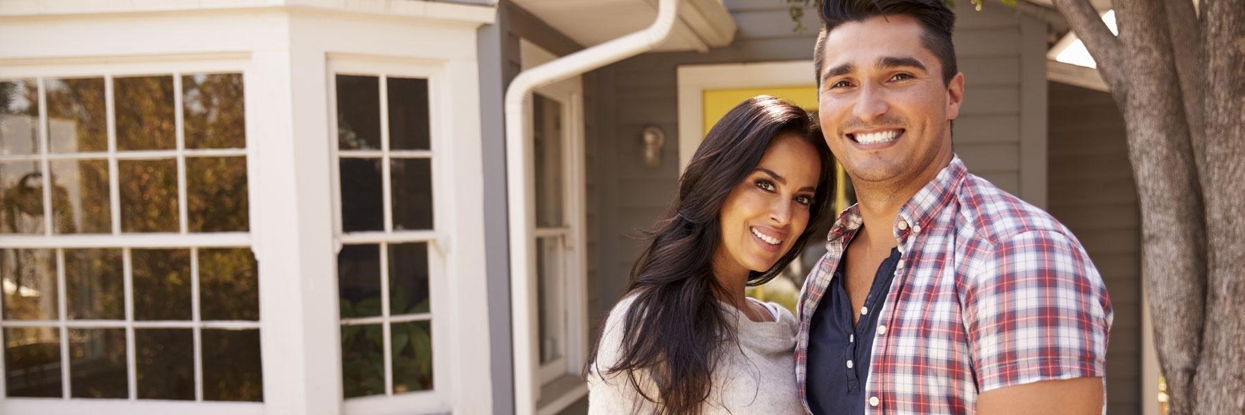 young couple smiling outside of home l cosmetic dentistry austin tx