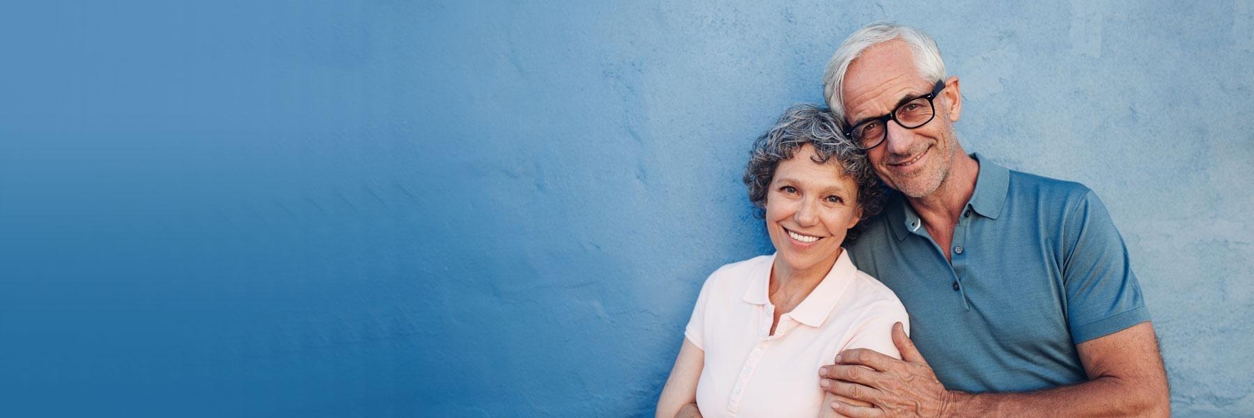 older couple hugging w/ blue background l dental crowns austin tx