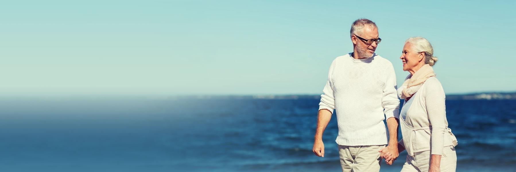 older couple walking on beach l tooth extractions austin tx